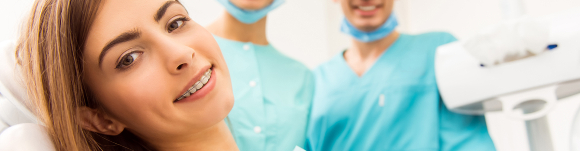 female smiling with braces in front of dental staff