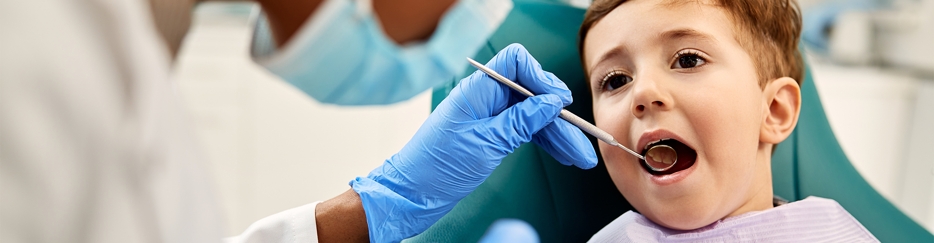 child opening mouth in dental chair