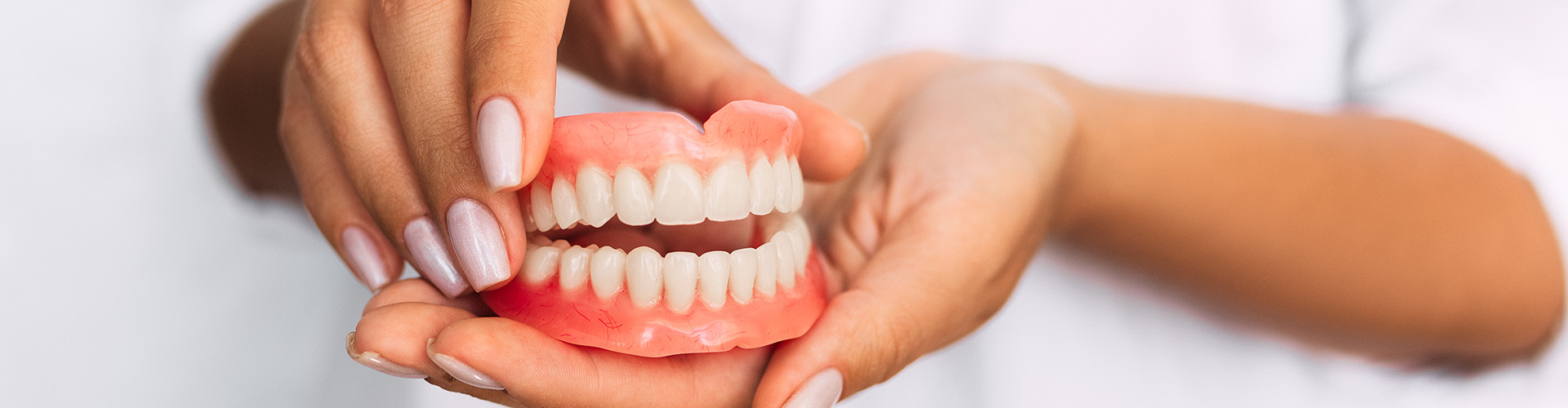 hands holding dentures