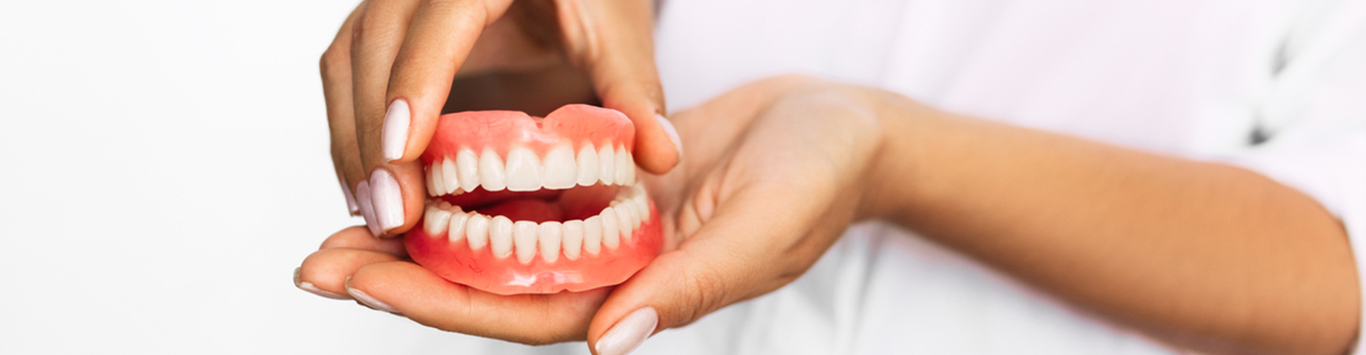 dentures in between two hands