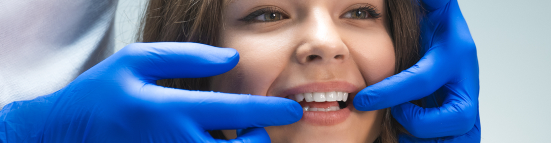 Dentist pointing to each end of young patients white smile 