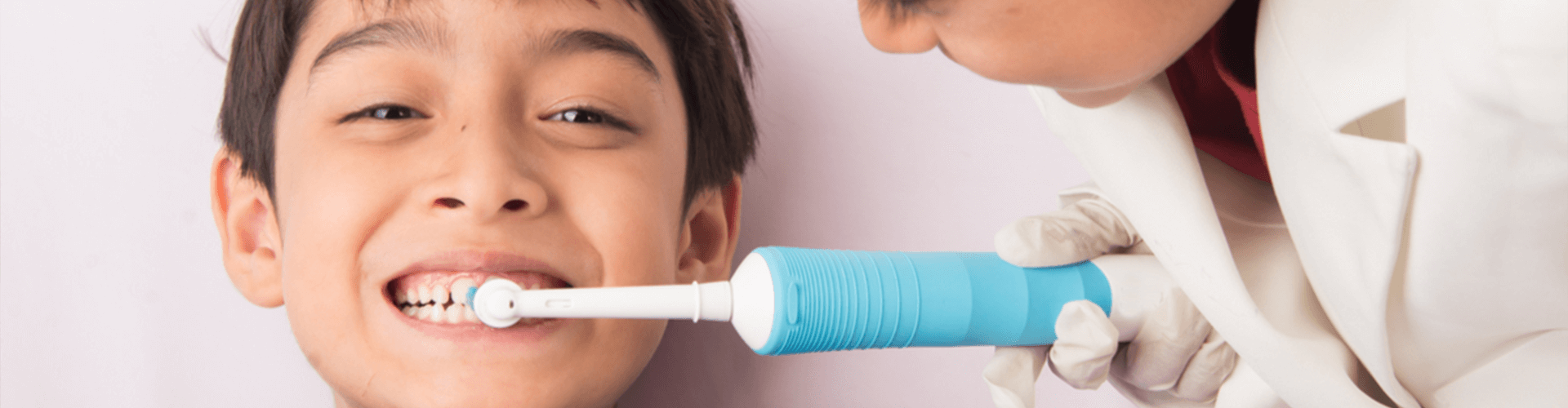 one child brushing another child's teeth 