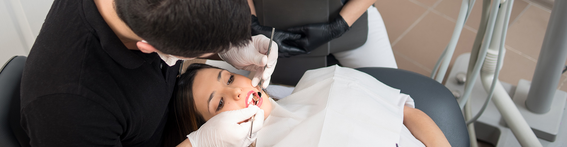 dental team working in mouth female patient