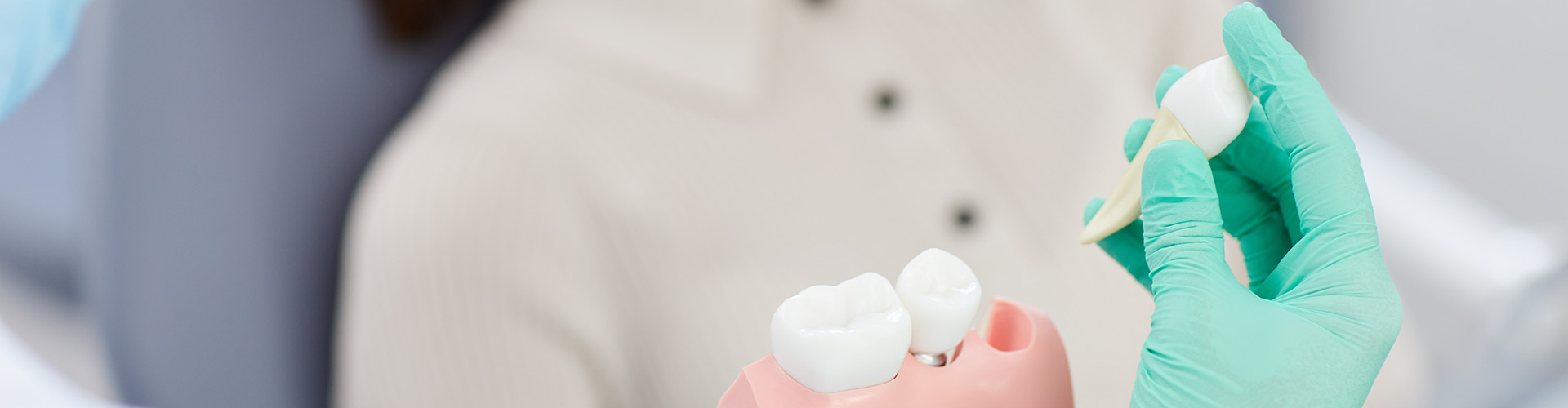 dental holding a tooth extraction model in front of smiling woman