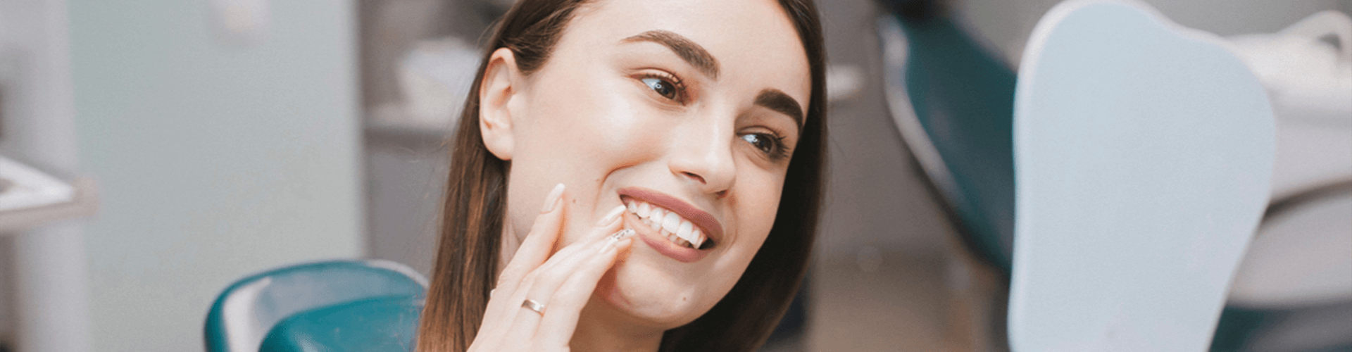 Woman admiring her white teeth in a mirror