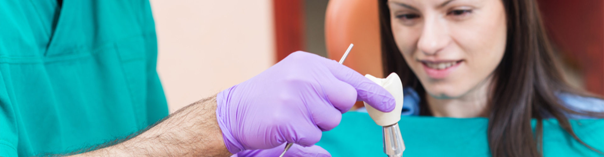 Dentist hands holding instrument for crown next to patient