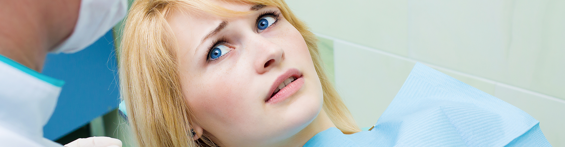 dentist holding dental tools over woman in dental chair