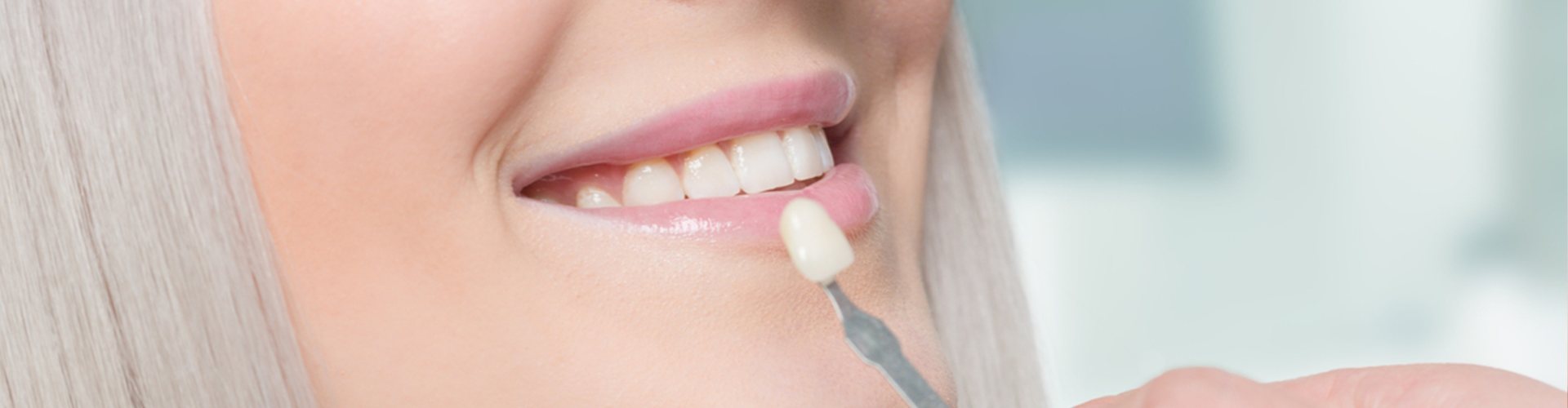 Holding a false tooth up to a smile