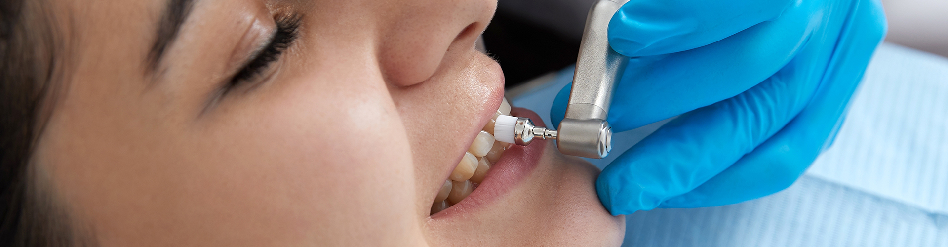 dental tool being used on woman's tooth