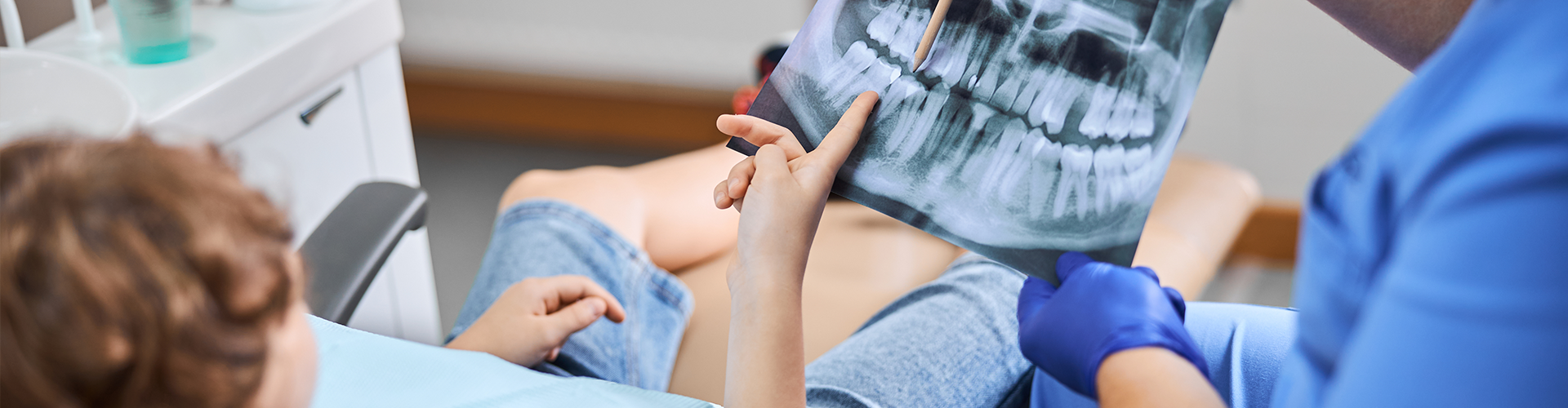 patient pointing at a dental x-ray held by gloved hands