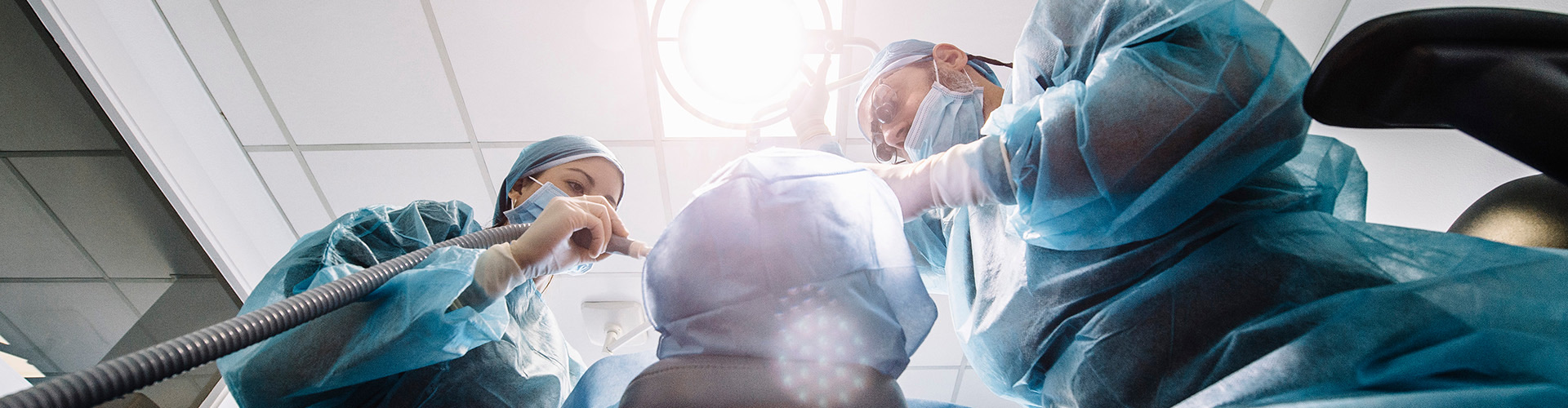 two oral surgeons performing oral surgery on a patient