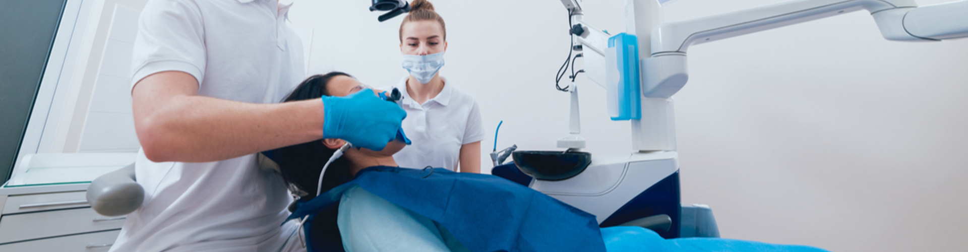 patient in dental chair with dental saff