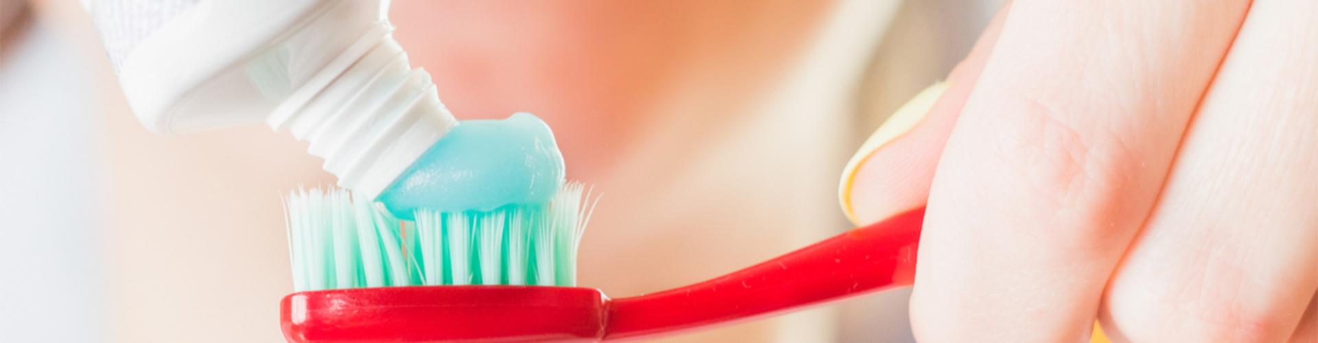 Toothpaste being squeezed onto a toothbrush 
